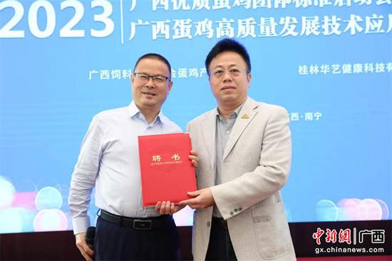 广西饲料工业协会会长沈水宝会长给广西大学博士生导师覃孟生（右）授予广西饲料工业协会总顾问。主办方供图